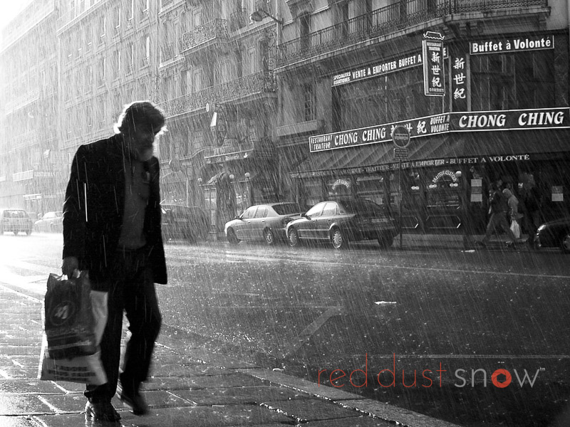 Paris Rain — a man walks along Rue du 8 Mai 1945 during a spring rain shower, near Gare de l'Est, Paris