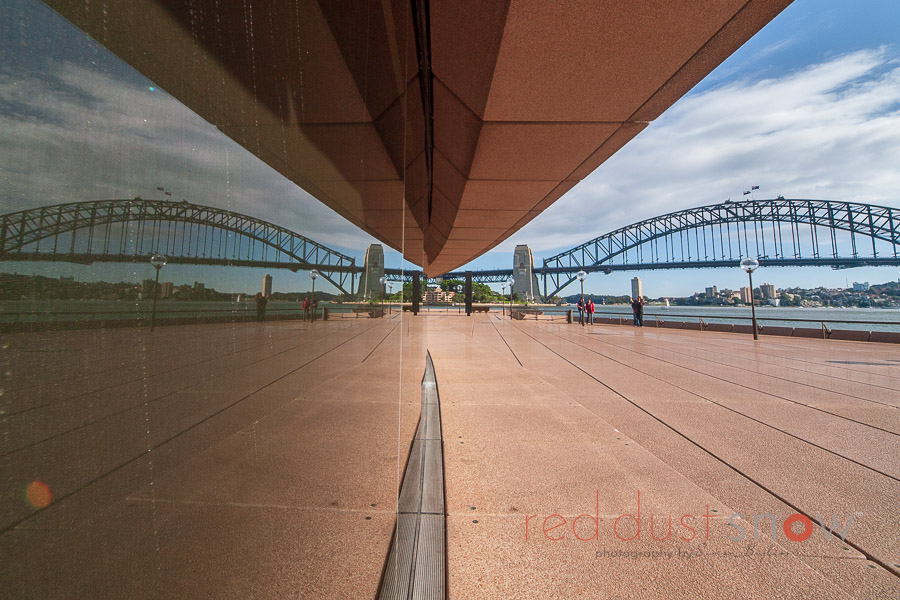 Sydney Harbour Bridge reflection on the window of the lower concourse of the Sydney Opera House, Sydney, NSW, Australia